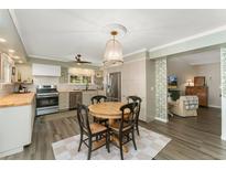 Charming eat-in kitchen with a round table, stainless steel appliances, and hardwood floors at 938 W Peakview Cir, Littleton, CO 80120