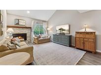 Cozy living room features a fireplace, plush seating, and a bright window for natural light at 938 W Peakview Cir, Littleton, CO 80120