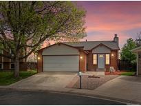 Charming single Gathering home with brick, two car garage, landscaped front yard and walkway with colorful sunset at 10536 Garrison St, Westminster, CO 80021