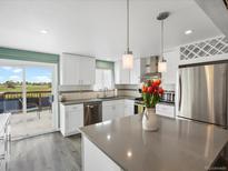 Bright kitchen features white cabinets, stainless steel appliances, and a gray countertop island at 10536 Garrison St, Westminster, CO 80021