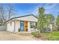 Charming home with a beautifully painted exterior, a vibrant turquoise door, and manicured landscaping at 6900 S Clermont St, Centennial, CO 80122