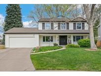 Charming two-story home with a well-manicured lawn, white exterior, black shutters, and an attached two-car garage at 6712 S Leyden Ct, Centennial, CO 80112