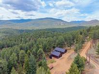 Stunning aerial view of mountain home surrounded by lush forest, providing privacy and a serene setting at 54 Zaza Ln, Evergreen, CO 80439