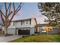 Charming two-story home with neutral gray paint, a brick-lined garage, and a cozy porch swing at 6508 E Euclid Pl, Centennial, CO 80111