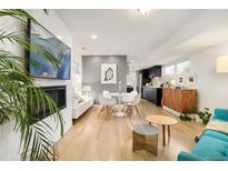 Open-concept living room with hardwood floors, fireplace, and modern furnishings at 3435 Lawrence St, Denver, CO 80205