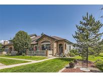 Charming home with stone accents, a well-manicured lawn, and a cozy front porch at 2700 W Greens Pl, Littleton, CO 80123