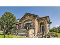 Charming home featuring a stone facade and inviting front porch with decorative accents and well-manicured landscaping at 2700 W Greens Pl, Littleton, CO 80123