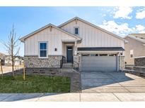 Charming two-story home featuring stone accents, a two-car garage, and manicured landscaping at 8926 S Rome Ct, Aurora, CO 80016