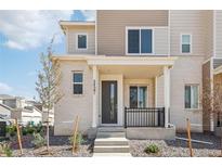 Modern two-story townhome with light brick exterior and covered porch at 24501 E 41St Ave, Aurora, CO 80019