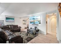 Spacious living room with large TV, leather sectional sofa, and decorative rug at 7995 E Mississippi Ave # J1, Denver, CO 80247