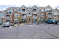 Attractive condo building with gray and stone facade, balconies, and convenient parking at 1881 S Dunkirk St # 106, Aurora, CO 80017