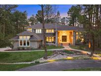 Charming home exterior with manicured lawn, stone accents, and inviting walkway through a wooded area at 510 Castle Pines Dr, Castle Rock, CO 80108