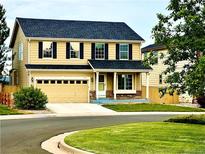 Inviting two-story home featuring a two-car garage, well-maintained lawn, and classic design elements at 16893 Trail View Cir, Parker, CO 80134