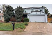 Charming two-story home featuring a front porch, attached two-car garage, and a well-maintained front yard at 15909 E Ford Pl, Aurora, CO 80017