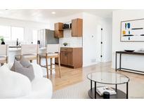 Inviting living room open to the kitchen with modern finishes and an abundance of natural light at 5261 Chandler Way, Denver, CO 80239