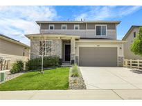 Charming two-story home featuring stone accents, a two-car garage, and a well-manicured front lawn at 1886 Makley Loop, Castle Rock, CO 80104