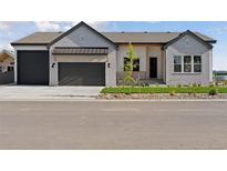 Charming single-story home featuring a brick facade, two-car garage, and a well-maintained front yard at 1425 Burt Ave, Berthoud, CO 80513