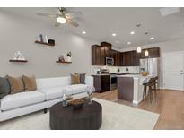Inviting living room with modern furnishings, open layout, and seamlessly connected to a stylish, well-equipped kitchen at 19733 W 93Rd Ln # D, Arvada, CO 80007