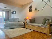 Inviting living room features hardwood floors, comfortable seating, and ample natural light from the sliding glass door at 6836 W 84Th Cir # 15, Arvada, CO 80003