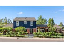 Charming two-story home with a beautiful blue and brick facade, surrounded by a well-manicured lawn at 3330 E Tennessee Ave, Denver, CO 80209