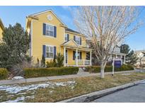Charming yellow two-story home featuring blue shutters and a welcoming front porch at 8720 E 29Th Ave, Denver, CO 80238