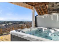 Relax in this hot tub with a view of the neighborhood and mountains at 1721 Wingfeather Ln, Castle Rock, CO 80108