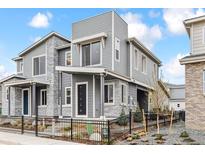 Contemporary home with gray siding, stone accents, and black metal fence at 4588 S Versailles St # B, Aurora, CO 80015