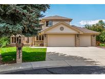 Two-story home with a three-car garage, brick accents, manicured lawn, and a large tree at 10227 Osceola Ct, Westminster, CO 80031