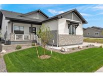 Charming home with manicured lawn, stone accents, and covered porch in a tranquil neighborhood at 5492 Woodroot Pt, Castle Rock, CO 80104
