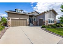 Charming home with a two-car garage, stone accents, and a well-manicured lawn and driveway at 26722 E Peakview Pl, Aurora, CO 80016