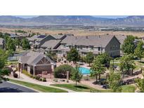 Community pool surrounded by townhomes and beautiful mountain views on the horizon at 4718 Raven Run, Broomfield, CO 80023