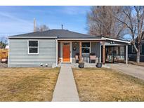 Charming gray home featuring an inviting front porch and well-maintained front yard at 6835 W 55Th Pl, Arvada, CO 80002