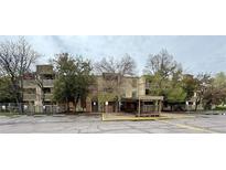 A multi-story apartment complex featuring mature trees and a covered entrance at 1302 S Parker Rd # 316, Denver, CO 80231