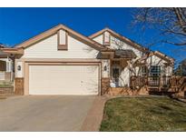 Beige house with a two-car garage and a wooden deck at 9488 Brook Ln, Lone Tree, CO 80124