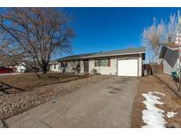 Ranch style home with a single car garage and mature landscaping at 1331 4Th St, Fort Lupton, CO 80621