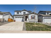 Charming two-story home with a two-car garage, well-kept lawn, and stone veneer accents at 6646 Merrimack Dr, Castle Pines, CO 80108