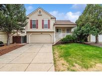 Two-story home featuring a well-kept lawn, an attached two-car garage, and mature landscaping at 21052 E 45Th Ave, Denver, CO 80249