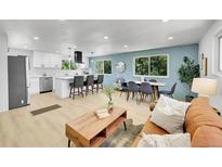 Open-concept living space featuring a modern kitchen, dining area, and a comfortable seating area with a leather sofa at 1173 Xenon St, Golden, CO 80401