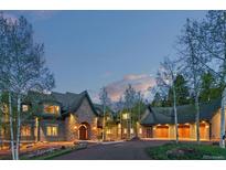 Stunning stone home with lush landscaping and mature trees, perfect for luxury living at 11406 Conifer Ridge Dr, Conifer, CO 80433