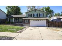 Charming two-story home with a well-maintained front yard and a spacious two car garage at 13833 W 68Th Ave, Arvada, CO 80004