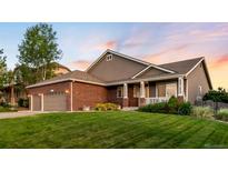 Charming two-story home with a well-manicured lawn, brick accents, a covered porch and attached two car garage at 1758 Parkdale N Cir, Erie, CO 80516