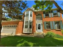 Charming two-story brick home with green shutters and a well-manicured lawn at 15292 E Hialeah Pl, Aurora, CO 80015