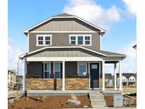 Charming two-story home featuring stone accents, a covered porch, and a well-manicured front yard at 22203 E 6Th Pl, Aurora, CO 80018