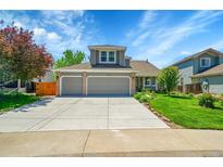 Charming two-story home with a well-maintained lawn and a spacious driveway leading to a two-car garage at 20530 Parker Vista Cir, Parker, CO 80138