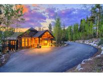 Stunning exterior view of the stone home, showing a winding drive and manicured landscaping at 41 Stillson Placer Ter, Breckenridge, CO 80424