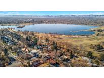 Scenic aerial view of a neighborhood, lake, and city skyline in the distance provides a picturesque setting at 4215 W Byron Pl, Denver, CO 80212