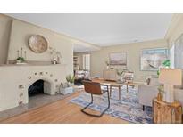 Bright living room features a cozy fireplace, hardwood floors, and neutral decor at 4215 W Byron Pl, Denver, CO 80212