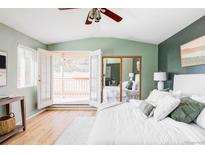 Bright main bedroom with ensuite balcony, ceiling fan, and mirrored closet doors at 4215 W Byron Pl, Denver, CO 80212