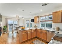 Bright kitchen featuring wooden cabinetry, granite countertops, stainless steel appliances, and hardwood flooring at 24285 E Wagon Trail Ave, Aurora, CO 80016