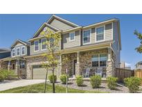 Charming two-story home with stone accents, a covered porch, and beautifully landscaped front yard at 417 S Ouray St, Aurora, CO 80017